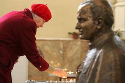 Una feligresa coloca una vela junto a un busto del Papa en una iglesia en Moscú.