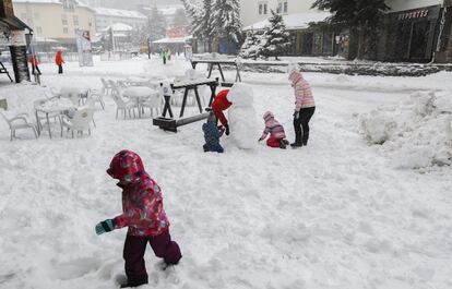 Una familia prepara un muñeco de nieve en la estación de esquí de Sierra Nevada, donde la fuerte nevada y el viento imperante han obligado a cancelar la prueba del gigante paralelo de snowboard de los Campeonatos del Mundo de Snowboard y Freestyle Ski Sierra Nevada 2017, el 14 de marzo de 2017.