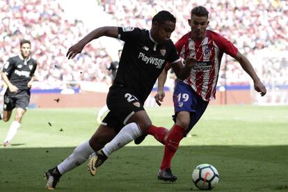 El delantero del Sevilla Luis Muriel disputa un balón ante Lucas Hernández.