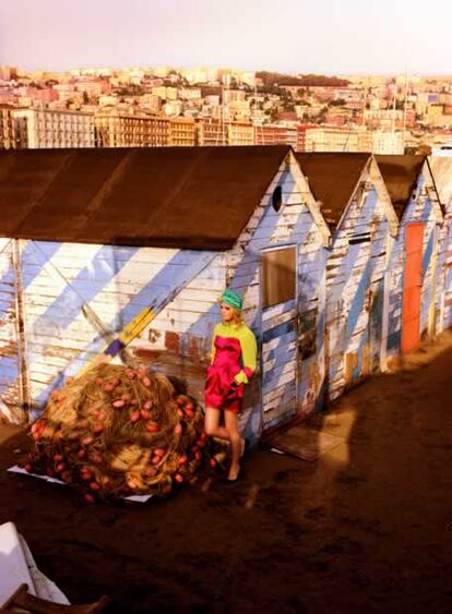 Otra mezcla colorista de resultado impactante tomada entre las casas de la playa napolitana: vestido corto fucsia sin tirantes, sobre una camisa verde pistacho, todo de Dolce & Gabbana. Las bailarinas azules son de Jil Sander. El turbante y el brazalete de plástico rosa son de Emilio Pucci.