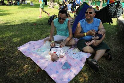 Una pareja cuida de sus gemelos durante la Marcha del Orgullo LGTB.