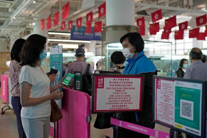Una mujer escanea este martes un código QR para el seguimiento de contactos con infectados de covid en un centro comercial de Hong Kong.