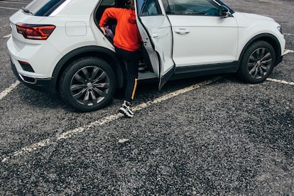 Un niño sube a un coche tipo SUV que sobresale de una plaza de aparcamiento en las afueras de Santiago de Compostela, este jueves.