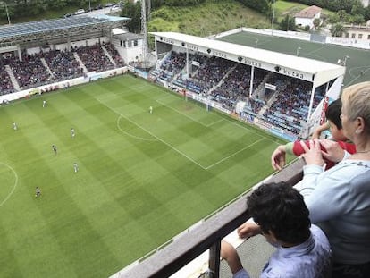 Una familia ve desde su vivienda un partido del &Eacute;ibar, en el estadio de Ipur&uacute;a, la temporada pasada. 