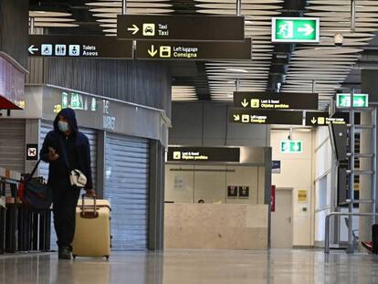 Un pasajero camina por el aeropuerto de Barajas entre tiendas y bares cerrados.