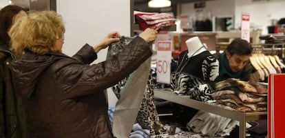 Una mujer observa una camiseta rebajada en Madrid. 