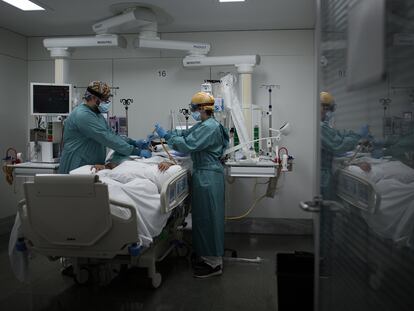 Dos enfermeros atienden a un paciente con covid-19 en la UCI del hospital Sant Pau de Barcelona