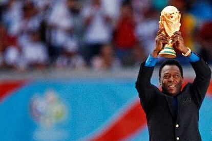 La leyenda del fútbol mundial, el brasileño Pelé, alza la Copa del Mundo durante la ceremonia inaugural en Múnich.