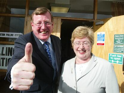 David Trimble, líder del Partido Unionista del Ulster, saluda a los fotógrafos junto a su esposa, Daphne, frente a su colegio electoral de Lisburn (Irlanda del Norte). La normalización definitiva del Ulster será uno de los retos principales del ganador de las elecciones en Reino Unido.