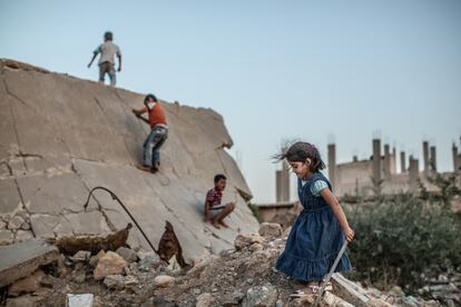 Un grupo de niñas y niños juegan entre la ruinas de una escuela. Los centros educativos y culturales fueron los principales objetivos durante la ocupación del Estado Islámico para minar la identidad del pueblo de Kobane.