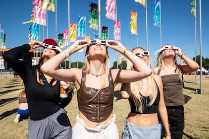 Mujeres observan el eclipse solar del 14 de octubre de 2023 en un festival de música en Austin.