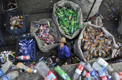 Una mujer trabaja clasificando botellas de plástico en una planta de reciclaje en la ciudad china de Hefei.