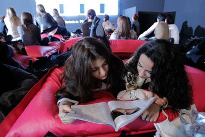 Varias chicas pasan el rato en el Cibelespacio al no haber conseguido una entrada para ver los desfiles.