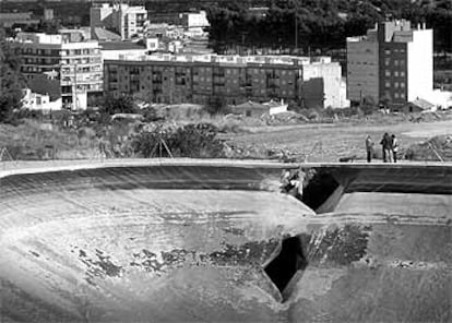 La balsa de riego que reventó en Chiva con el boquete que dejó salir el agua.