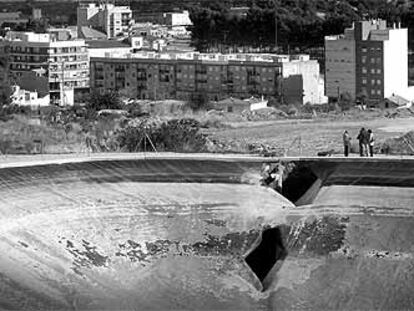 La balsa de riego que reventó en Chiva con el boquete que dejó salir el agua.