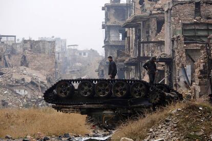 Fuerzas de El Asad revisan un tanque dañado en Alepo.