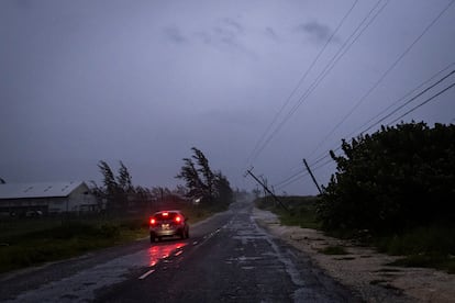 Un auto viaja junto a un poste de electricidad colapsado por los vientos del huracán, en la costa sur de Jamaica, el 3 de julio.