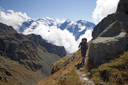 Un senderista en la Haute Route, con el Grand Combin, la montaña más alta de Alpes Peninos occidentales, al fondo.