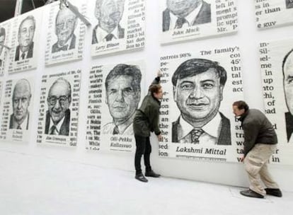 José María Cano, a la derecha, coloca ayer sus cuadros en una galería de Londres.