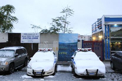 Dos coches de policía cubiertos con nieve en Nueva York.