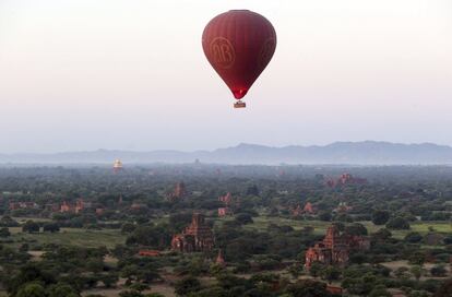 Un globo aerostático vuela sobre los antiguos templos de Myanmar antes del amanecer en el antiguo distrito de Bagan. 
