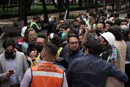 La gente congregada en las calles graba con sus teléfonos móviles durante el temblor de este lunes.