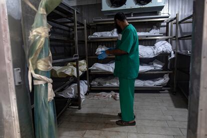 Un empleado del hospital Al Nasser de Jan Yunis, en el sur de Gaza, en la morgue del centro rodeado de cuerpos de víctimas de ataques israelíes.