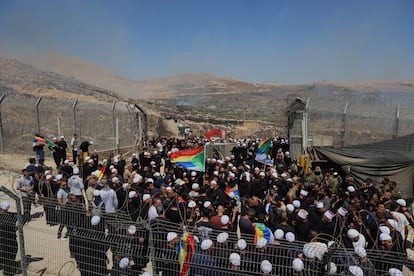 Cientos de personas se agolpan con la bandera drusa en Majdal Shams, bajo ocupación israelí, para pasar al otro lado de la valla que les separa de la Siria administrada por Damasco.