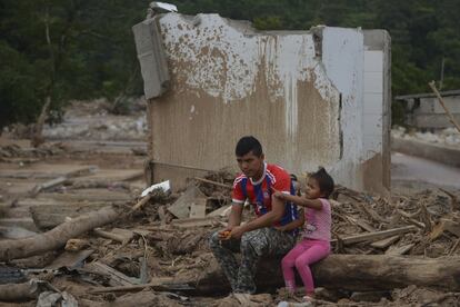 En la imagen, un hombre y su hija permanecen sentados en mitad del desastre causado por el temporal en Mocoa (Colombia), el 4 de abril de 2017.