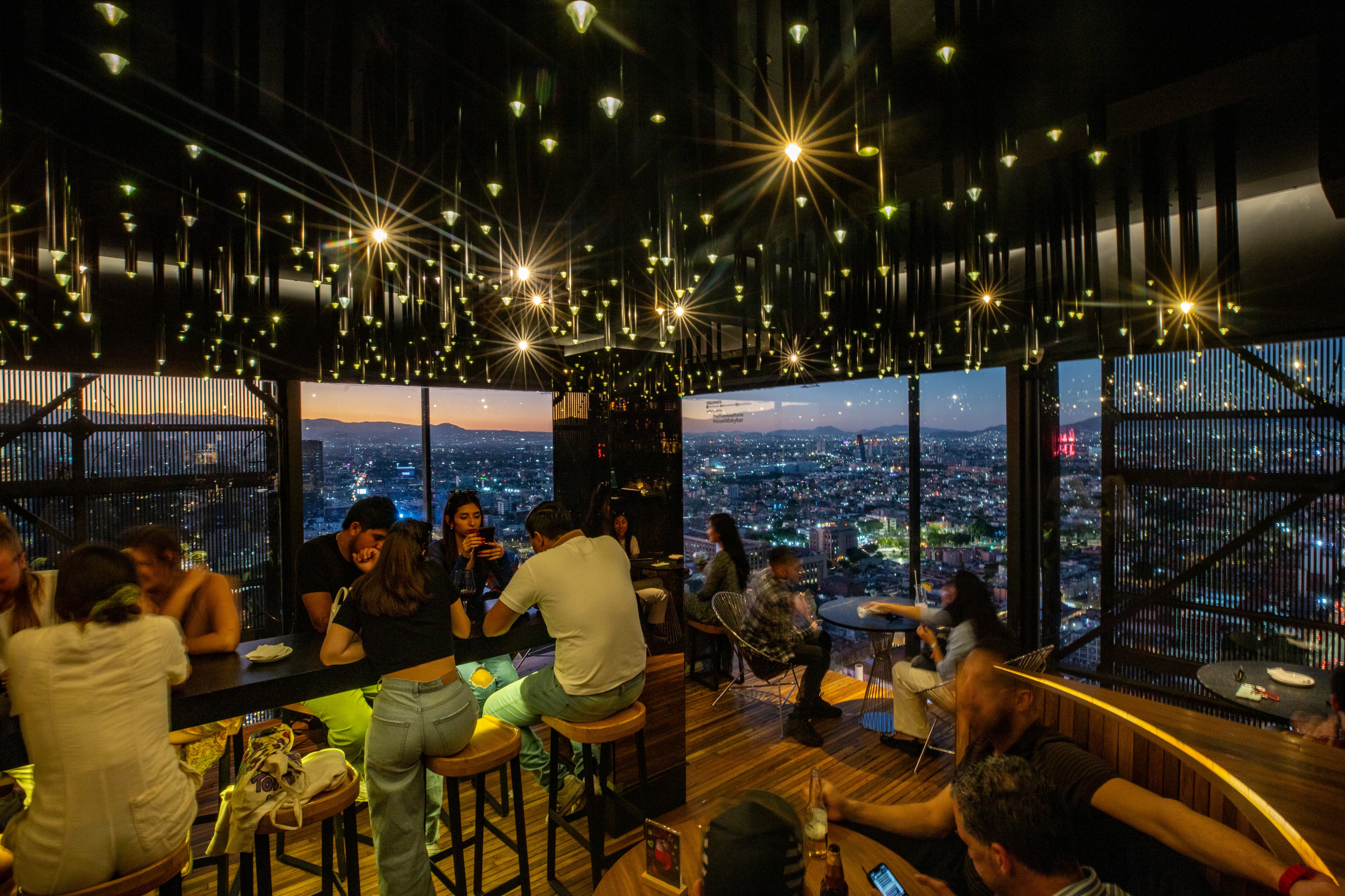 Personas disfrutan de la vista panorámica de la ciudad desde el Nivel 40 Sky Bar de la Torre Latinoamericana.