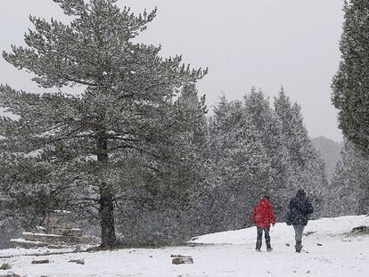 Dos excursionistas disfrutan de la primera nieve caída en las inmediaciones de Sant Joan de Penyagolosa, en Castellón, ayer.
