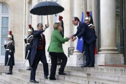 El presidente de Francia, François Hollande (2d), recibe a la canciller alemana Angela Merkel (c), a su llegada al Palacio del Elíseo de París (Francia), donde se celebra la segunda cumbre del empleo juvenil, hoy, martes 12 de noviembre de 2013.
