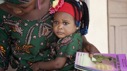 Belvine, de Benín, espera con su madre la visita a la enfermera para el control mensual del tratamiento preventivo de tuberculosis.