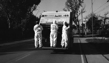 Unos recolectores de basura provistos con uniformes en los que se lee el lema 'Quédate en tu casa' trabajan por las calles de Salsipuedes, en la provincia de Córdoba, Argentina.