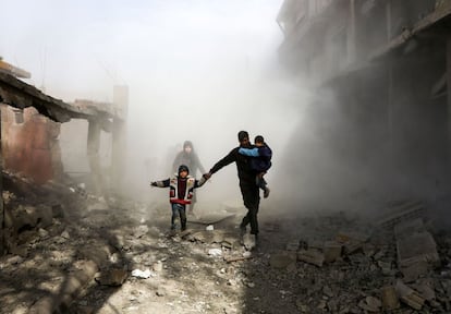 Ciudadanos sirios huyen de los ataques aéreos del régimen en la ciudad de Jisreen, controlada por los rebeldes, a las afueras de Damasco (Siria).