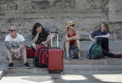 Un grupo de turistas descansan junto a las Torres de Serranos, en Valencia.