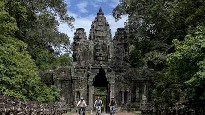 Un grupo de turistas recorre el enorme complejo de Angkor en bicicleta.