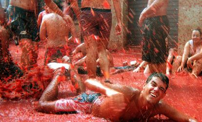 Buñol (Valencia), 22 de agosto de 2000. Un joven se divierte nadando en el mar de tomate que queda en las calles de la localidad después de la tomatina, popular batalla en la que más de 30.000 personas se arrojan unos 120.000 kilos de tomates maduros.