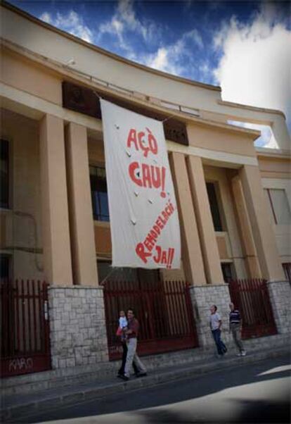 Una pancarta denuncia, en la fachada del instituto Ausiàs March, el deplorable estado del edificio.
