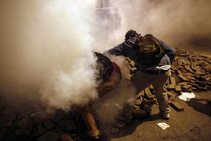 Los manifestantes tratan de atrapar y de tirar latas de gas lacrimógeno durante los choques con los antidisturbios, en las protestas contra el primer ministro de Turquía, Recep Tayyip Erdogan.