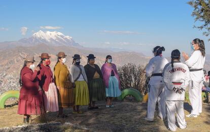 Las alumnas e instructoras conversan durante el taller en El Alto, con la montaña Illimani de fondo, y comparten sus experiencias y la violencia que han sufrido tanto en el hogar como en la calle. El año pasado se registraron 113 feminicidios, 108 en 2021, uno cada tres días.