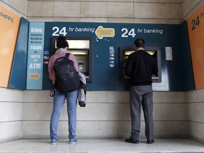 Dos clientes usan un cajero del Banco de Chipre.