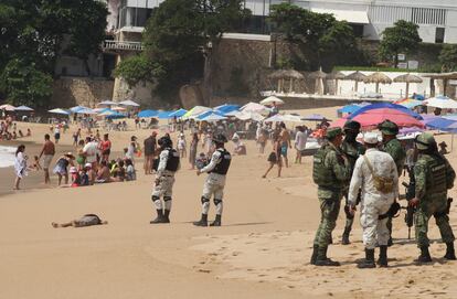 Fuerzas de seguridad y turistas junto a un cuerpo en una playa de Acapulco (México), el 12 de noviembre de 2022.