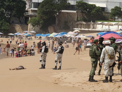 Fuerzas de seguridad y turistas junto a un cuerpo en una playa de Acapulco (México), el 12 de noviembre de 2022.