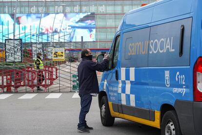 Una persona sin hogar pide ayuda a trabajadores del Samur Social a las puertas de Ifema.