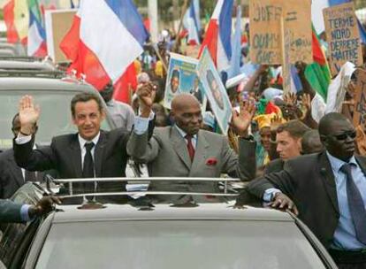 Nicolas Sarkozy (izquierda) y el presidente senegalés, Abdoulaye Wade, saludan durante un recorrido por la ciudad de Dakar.