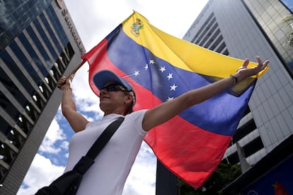 Una mujer sostiene una bandera de Venezuela en las calles de Caracas.