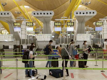 Pasajeros con sus maletas en las instalaciones de la Terminal T4 del aeropuerto de Madrid-Barajas. 