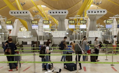 Pasajeros con sus maletas en las instalaciones de la Terminal T4 del aeropuerto de Madrid-Barajas. 