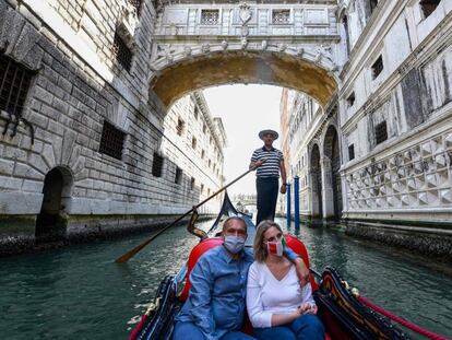 Una pareja disfruta de un paseo en góndola bajo el Puente de los Suspiros de Venecia (Italia).